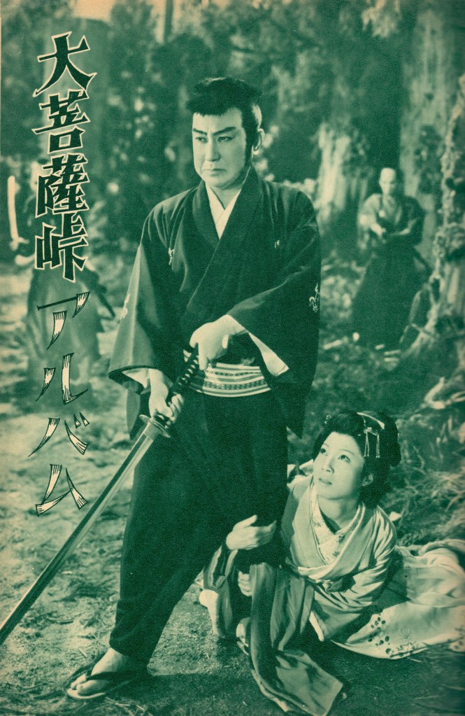 A samurai holding a sword stands confidently with a woman crouching beside him, both dressed in traditional Japanese attire, in a forest setting.