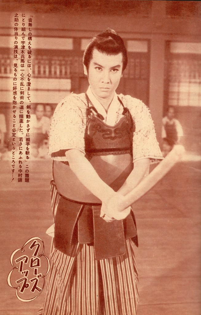 A samurai in traditional attire demonstrating a martial arts pose with a wooden sword, surrounded by spectators in a dojo setting.