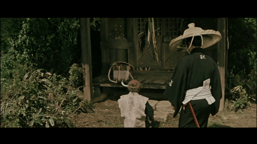 A samurai in traditional attire with a straw hat walks alongside a young child, both approaching a wooden structure surrounded by greenery.
