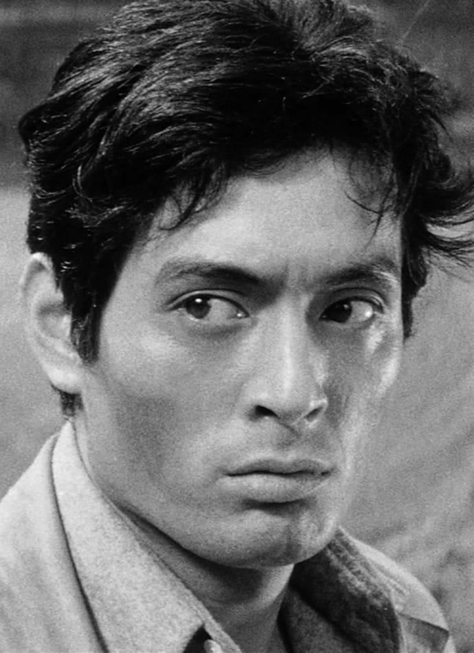 Close-up portrait of a man with dark hair, looking intently off-camera with a serious expression.