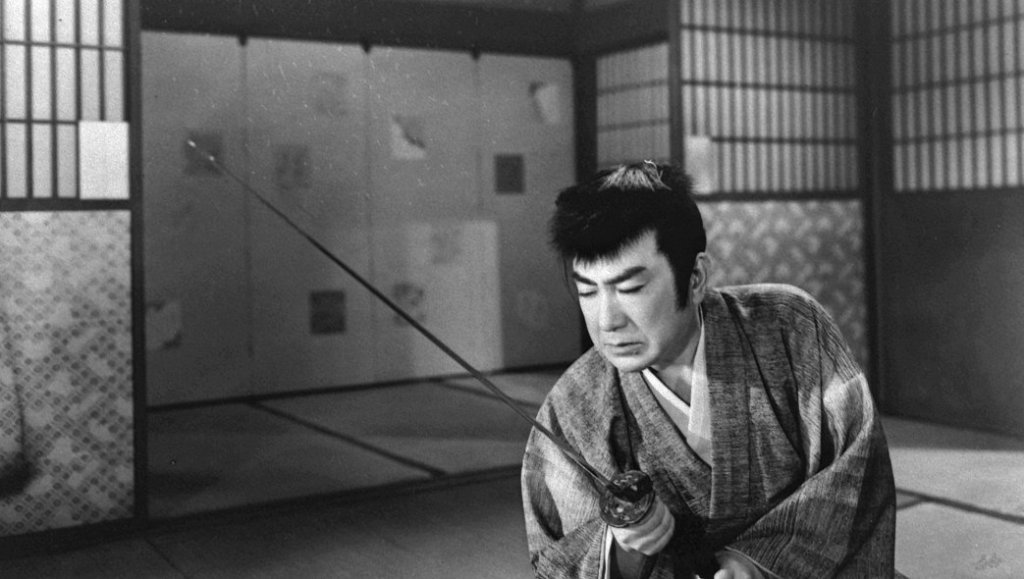 A man in traditional Japanese attire practices with a katana in a minimalist room with sliding doors and tatami mats.